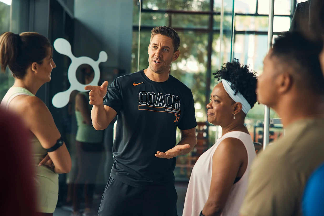 Orangetheory coach talking with members before class