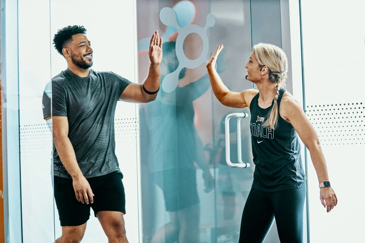 Coach and member high-fiving in the Orangetheory studio